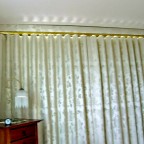 This pelmet fixed to a ceiling, is an original design made possible by the Uni-Q track profile. It is cut out to go around the cornice and uses U-pleat décor rod fixed to the base of the pelmet. The curtain runs on the rod.